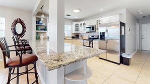 A modern kitchen with white cabinetry, a granite countertop, and stainless steel appliances. - Riverfront home near downtown Tampa with panoramic river views streaming WD (Tampa)