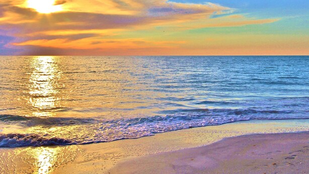 A beach with a sunset over the ocean. - Spacious and dog friendly close to the Gulf and beaches AC WIFI and WD (Treasure Island)