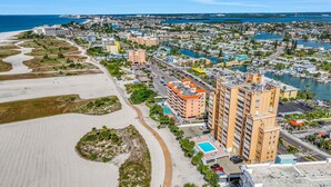 An aerial view of a coastal city with a beach, water bodies, and a mix of residential and commercial buildings. - Spacious and dog friendly close to the Gulf and beaches AC WIFI and WD (Treasure Island)