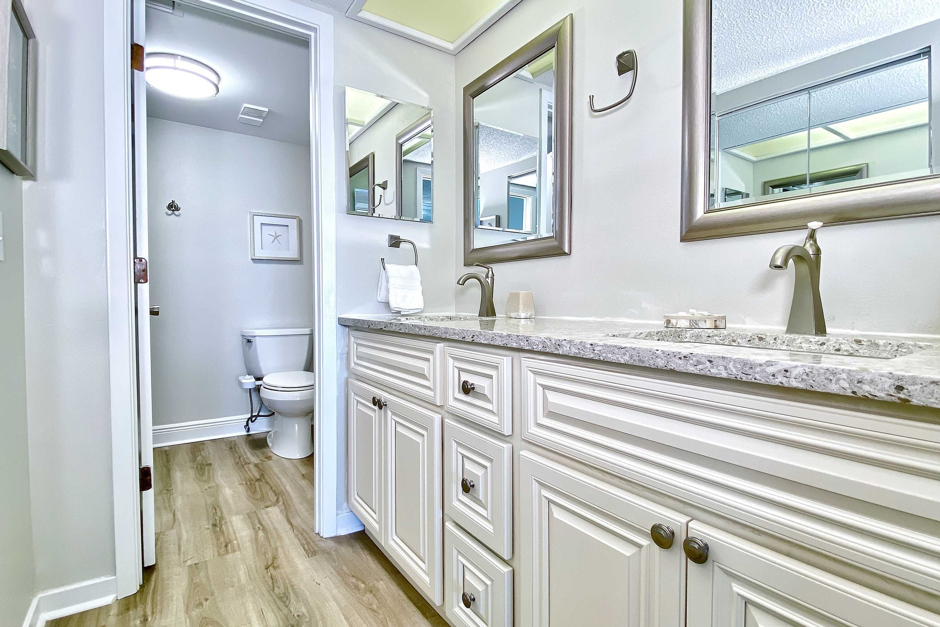 Un bagno con un mobile lavabo bianco, uno specchio grande e un water.
