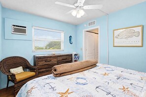 A bedroom with a bed, a chair, a dresser, a ceiling fan, and a framed picture on the wall. - Charming Gulf front condo with views of Belleair Beach with central AC (Belleair Beach)