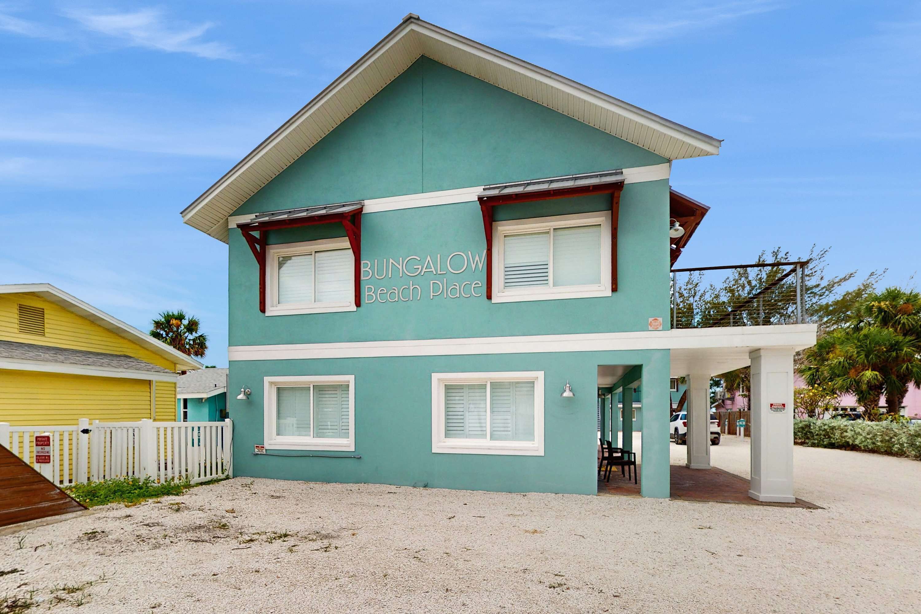 A two-story building with a sign reading "BUNGALOW Beach Place."