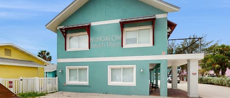 A two-story building with a sign reading "BUNGALOW Beach Place."
