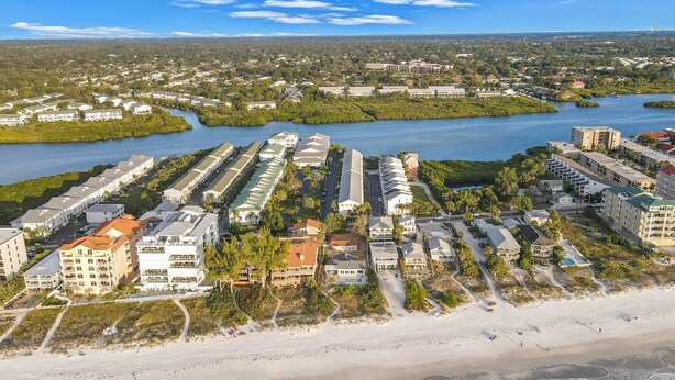 A coastal residential area with beachfront properties, a river, and a marina. - Beachfront condo with balconies grill AC and pool access steps from the sand (Indian Shores)