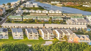 A coastal hotel with multiple buildings, a beach, and a marina. - Beachfront condo with balconies grill AC and pool access steps from the sand (Indian Shores)