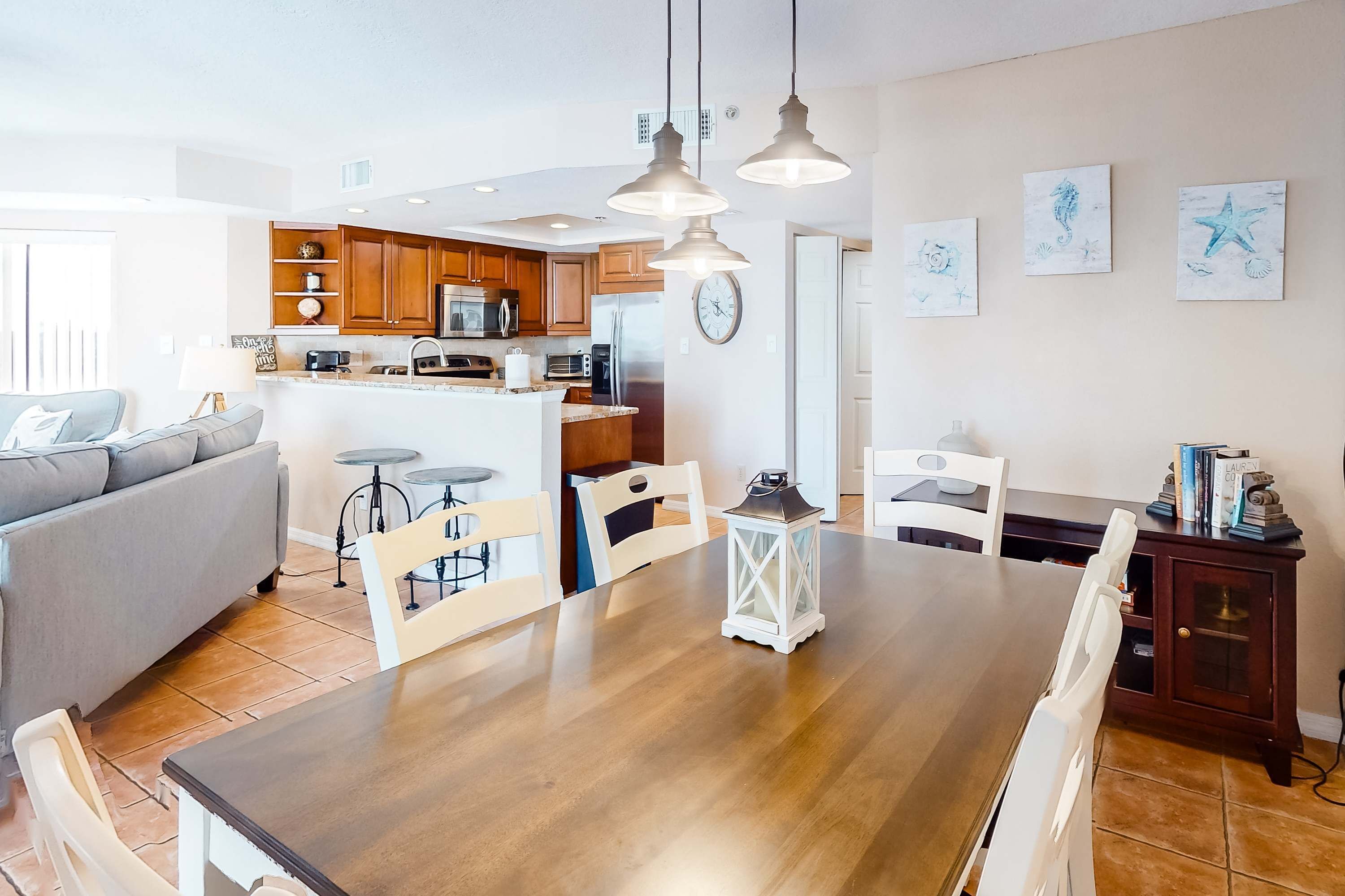 Une cuisine moderne avec des meubles en bois, un îlot central et des luminaires suspendus.