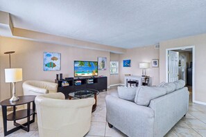 A living room with a sofa, armchair, TV, and a coffee table.