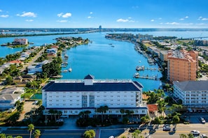 Un hotel con un patio central, un puerto deportivo con barcos y vistas al agua y al horizonte de la ciudad.