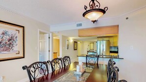 A dining area with a wooden table, black metal chairs, and a chandelier.