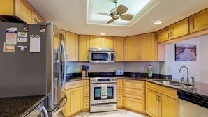 A kitchen with wooden cabinets, stainless steel appliances, a microwave, oven, and a dishwasher.