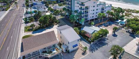 Un hôtel situé sur la côte, composé de plusieurs bâtiments, offrant une vue sur la plage et disposant d’un parking.
