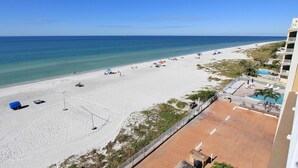 Una spiaggia con vista chiara sull'oceano, una spiaggia sabbiosa e un edificio con piscina.