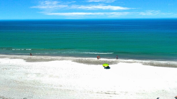 Ein Strand mit klarem, blauen Wasser und einem sandigen Ufer.