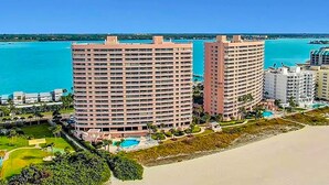 Un hôtel situé en bord de mer, doté d’une piscine, de plusieurs balcons et offrant une vue sur l’océan.