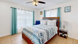 A bedroom with a bed, a nightstand, a ceiling fan, and curtains. - Centrally located dog friendly comfortable home with AC and WD (Largo)