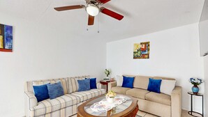 A living room with two sofas, a coffee table, a ceiling fan, and artwork on the walls. - Centrally located dog friendly comfortable home with AC and WD (Largo)