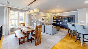 A modern living room with a dining area, a sofa set, and a kitchen area with bar seating. - Dog Friendly Retreat w/Bay Views, Pool, Spa & Onsite Marina (Clearwater)