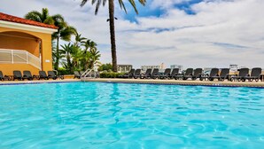 A clear blue pool with lounge chairs and palm trees. - Dog Friendly Retreat w/Bay Views, Pool, Spa & Onsite Marina (Clearwater)