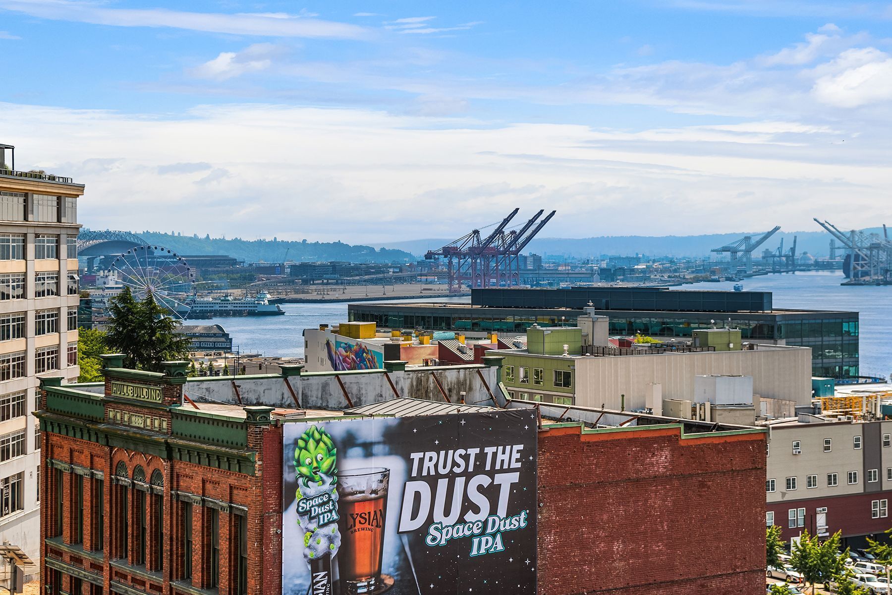A cityscape with a prominent advertisement for Space Dust IPA beer.