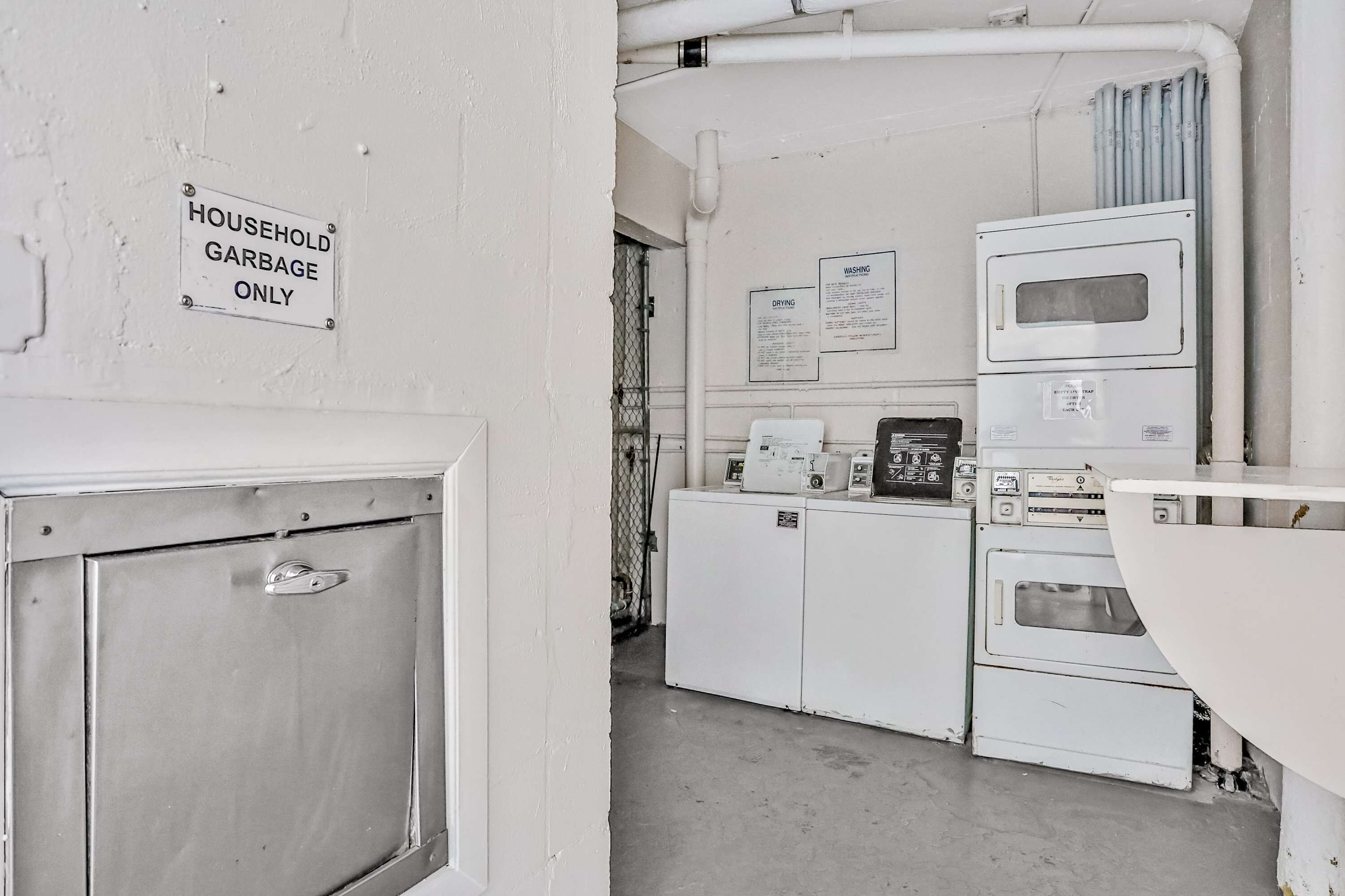 A laundry room with a sign indicating it's for household garbage only.