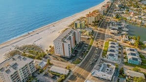 Oversigtsbillede af et kystområde med et hotel ved stranden, veje og boligbygninger.