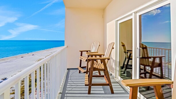 En balkon med udsigt over strand og hav.