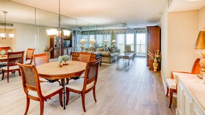 A spacious living room with a dining area, large windows, and a ceiling fan. - Second floor condo with pool and tennis court private WD and central AC (Clearwater)