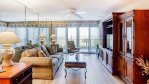 A spacious living room with a sofa set, a coffee table, and a television. - Second floor condo with pool and tennis court private WD and central AC (Clearwater)
