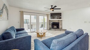 Un salon moderne avec un canapé bleu, une table basse ronde et une cheminée.