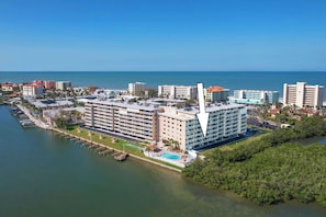 A hotel with a pool, waterfront view, and multiple floors.