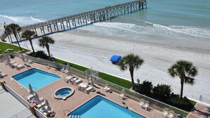 A resort with two swimming pools, a beach, and a pier.