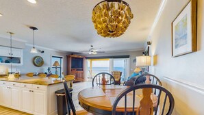 Een ruime keuken met een houten eiland, witte kasten en een eethoek met een ronde tafel en stoelen.