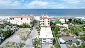 Ein Küstenhotel mit mehreren Gebäuden, einem Strand und Palmen.