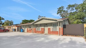 Een gelijkvloers huis met een garage, een omheinde achtertuin en een heldere lucht.