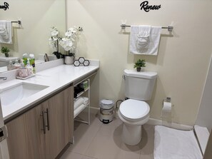 Een haardroger, handdoeken, zeep, toiletpapier