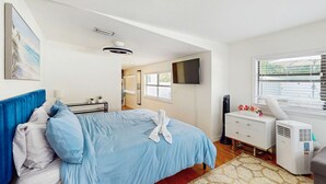 A bedroom with a bed, a dresser, a TV, and a window with blinds. - Dog friendly bungalow with a fenced yard deck washer dryer and AC (Tampa)