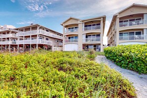 Un hôtel à plusieurs étages, doté de balcons et d’un espace paysager agrémenté de verdure.