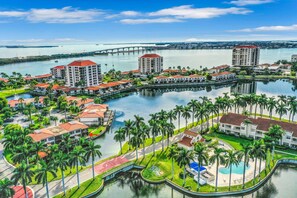 A resort with multiple buildings, a central pool, and a bridge over water. - Lakefront resort condo with furnished deck heated pool pool spa and tennis (St. Petersburg)