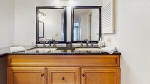 Une salle de bain avec un meuble-lavabo double, deux vasques et un grand miroir au-dessus.