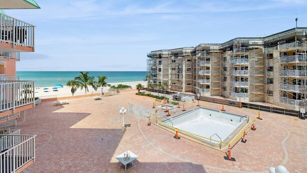 Un hôtel doté d'une piscine, offrant une vue sur la plage et comprenant plusieurs balcons.