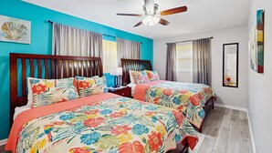A hotel room with two beds, a ceiling fan, and a large window with curtains. - Inviting ranch home near the beach Florida room alfresco dining (Clearwater)