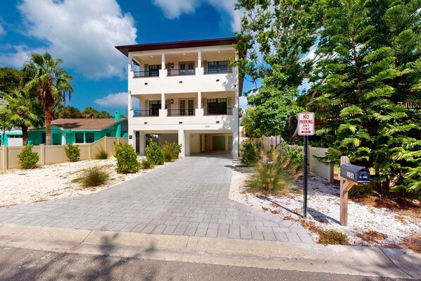 A multi-story building with a gated driveway and a mailbox.