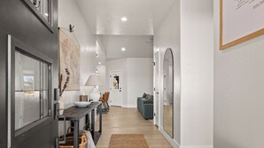 Un interior moderno con comedor, un sofá y un espejo grande.