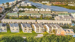 Una zona turística costera con varios edificios hoteleros, un puerto deportivo y una playa.
