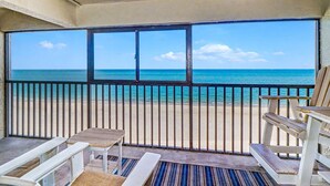 Ein Balkon mit Blick auf den Strand und das Meer.