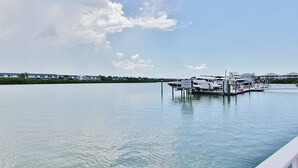 A marina with boats docked, calm water, and a clear sky. - Gulf side condo with heated pool hot tub central AC and WD snowbird friendly (Indian Shores)