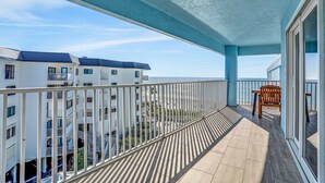 Ein Balkon mit Blick auf ein Gebäude und das Meer.