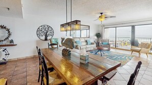 Ein großzügiger Wohnbereich mit einem Holzespeise-Tisch, einer Couch und einem Balkon mit Blick.