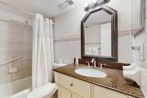 Ein Badezimmer mit Dusche, Toilette, Waschbecken und Waschtisch.