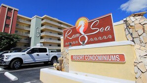 Ram Sea Resort -lomahuoneistojen kyltti, jonka edessä on valkoinen maastoauto pysäköitynä.